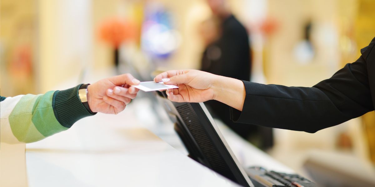 Guest and receptionist exchanging a key card at the front desk of a locally owned lodging, highlighting personalized service.