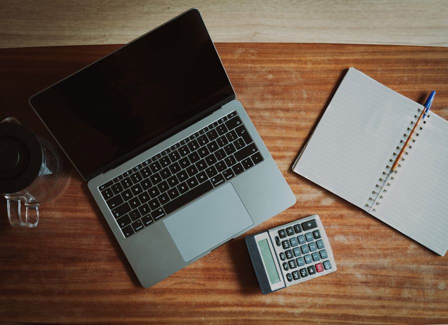 A clean, professional image of house keys next to a calculator, symbolizing the financial calculation and decision-making involved in choosing a real estate commission model.